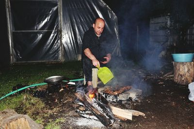 Full length of man preparing food on barbecue grill