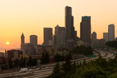 Modern buildings in city against sky during sunset