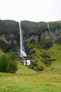Scenic view of waterfall against sky
