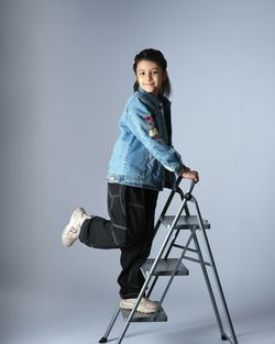 Portrait of young woman standing against white background