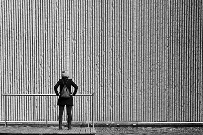 Rear view of woman standing against wall