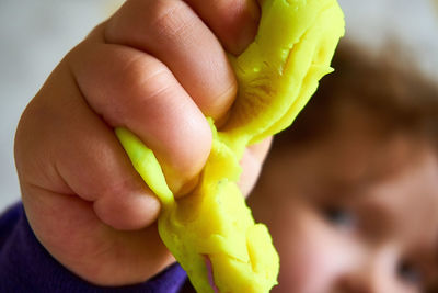 Close-up of hand holding yellow leaf