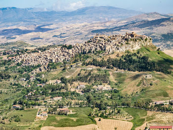 High angle view of houses and agricultural field against sky