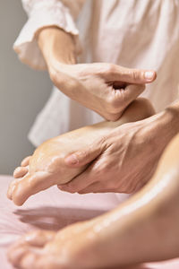 Midsection of massage therapist massaging feet