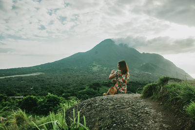 Man looking at mountain against sky