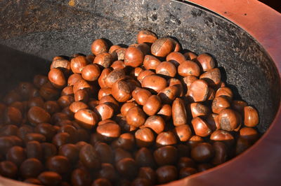 Roasted chestnuts in a large pan with sunlight