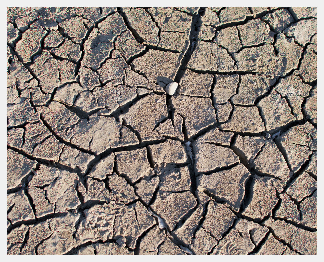 FULL FRAME SHOT OF CRACKED LAND IN WINTER