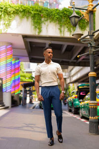 Full length portrait of young man standing in city