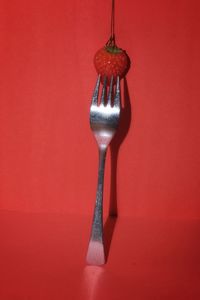 Close-up of wineglass against red background