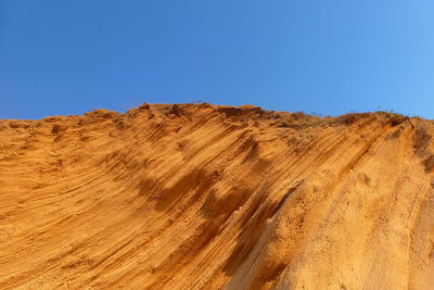 View of rocky mountains against clear blue sky