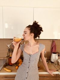 Young woman drinking glass on table