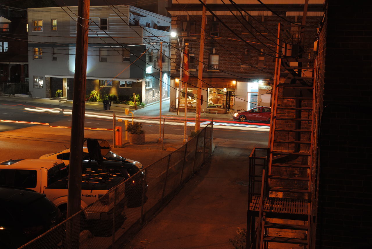 HIGH ANGLE VIEW OF ILLUMINATED ROAD AT NIGHT