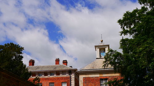 Low angle view of trees and buildings against sky