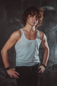 Portrait of young man standing against wall