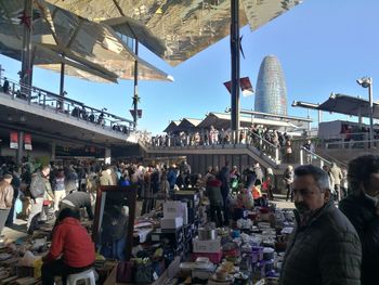 People standing at market in city against sky