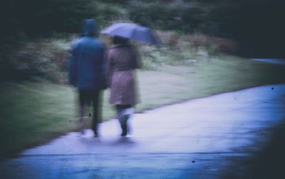 Rear view of people walking on road