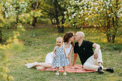 A happy family with one small child walking together in the park in the summer outdoors 