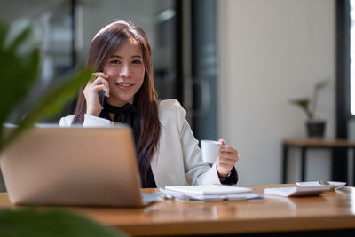 Young businesswoman using laptop at office