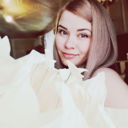 Portrait of smiling young woman with white flower bouquet