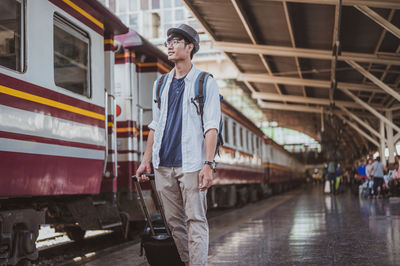 Man standing on train at railroad station