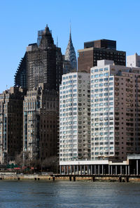 Buildings in city against clear sky