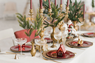 Christmas serving of a festive new year's dinner. candles in candlesticks, spruce branches, red 