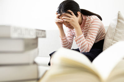 Midsection of man sitting on book