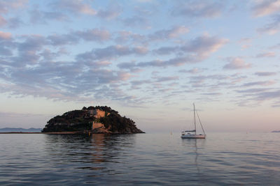 Sailboat on sea against sky during sunset