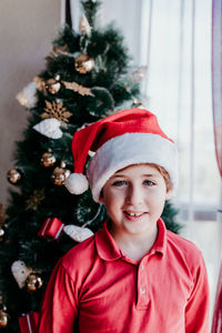 Smiling boy wearing santa hat at home
