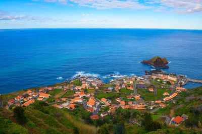 High angle view of townscape by sea against sky