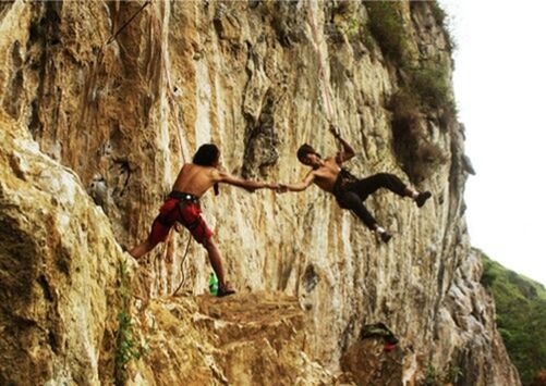 LOW ANGLE VIEW OF MAN ON CLIFF