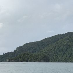 Scenic view of sea and mountains against sky