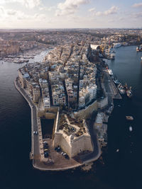 High angle view of cityscape by sea against sky