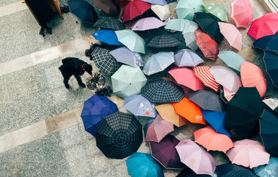 High angle view of man bending on street with umbrellas during monsoon