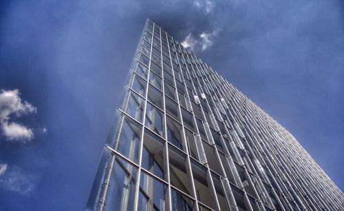 Low angle view of modern building against cloudy sky