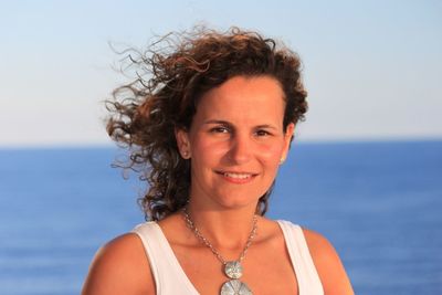 Portrait of beautiful happy woman with curly hair against horizon