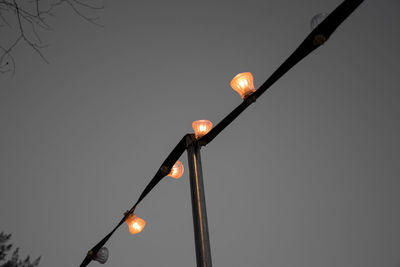 Low angle view of illuminated street light against clear sky