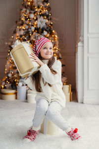 Midsection of woman with christmas tree in box