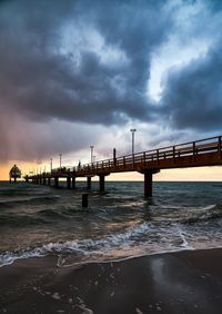 Bridge over sea against sky during sunset