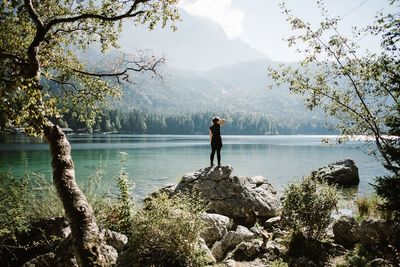 Man standing by lake against sky