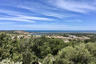 Aerial view of townscape by sea against sky