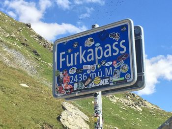 Close-up of road sign against blue sky