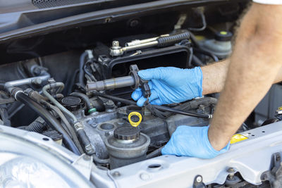 Midsection of mechanic repairing car
