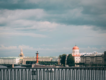 Buildings in city against cloudy sky