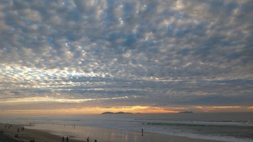 Scenic view of sea against dramatic sky during sunset