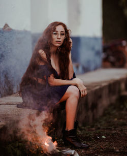 Portrait of young woman sitting outdoors