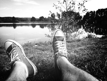 Low section of person relaxing on lakeshore