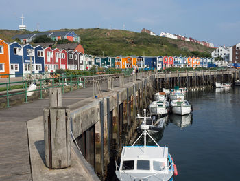 Boats moored on sea against buildings in city