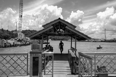 People at observation point against cloudy sky