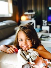 Portrait of smiling girl with toys at home